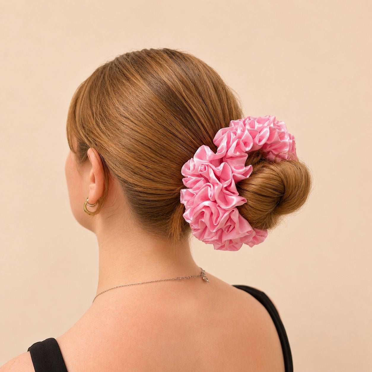 Ajoutez une touche douce et raffinée à vos coiffures avec ce chouchou en satin rose. Son tissu délicatement brillant apporte une allure élégante tout en prenant soin de vos cheveux grâce à sa matière douce et agréable à porter.